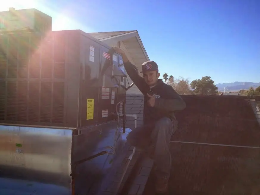HVAC technician performing Boiler Repair on a rooftop unit in Jeffersontown